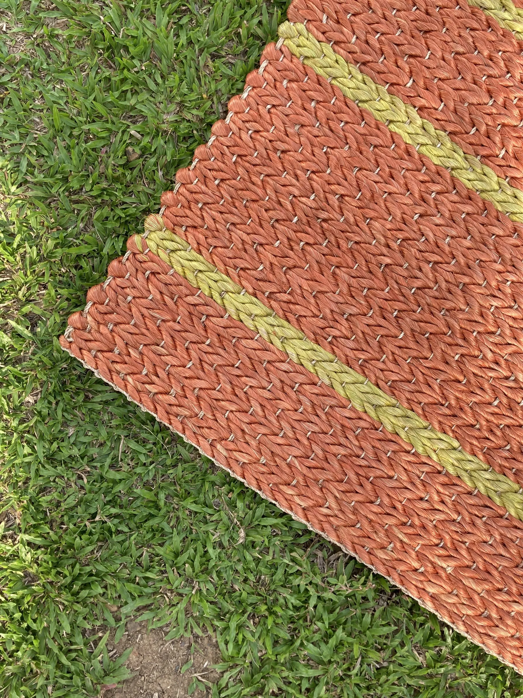 Terracotta dyed abaca rug on grass